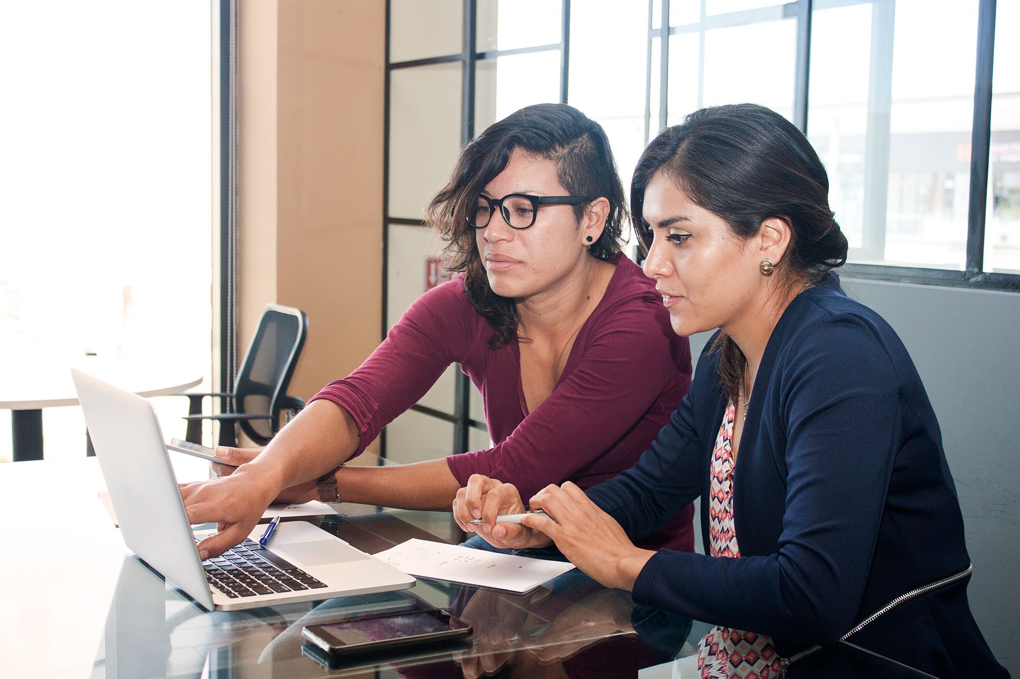 Two women reviewing information on a laptop